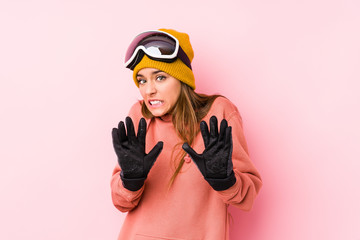 Young caucasian woman wearing a ski clothes isolated rejecting someone showing a gesture of disgust.