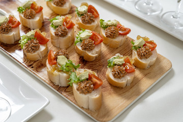 Catering, snacks on the table. Mini Sandwiches with pate and tomatoes, decorated with salad.