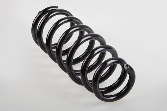 New black metal shock spring isolated on white background. Car spare parts