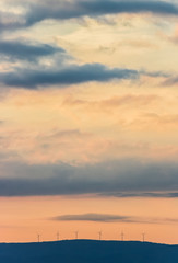 champ d'éolinnes sur fond soleil couchant