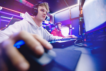 Fototapeta na wymiar Professional gamer playing tournaments online video games computer with headphones, red and blue