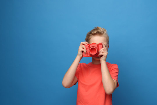 Photographer, child with a camera.  Portrait of a boy on a blue background.
