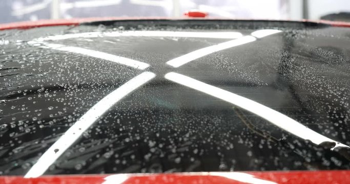 Manual wash for perfect clean car. Cleaning car using high pressure water, Man cleaning vehicle with high pressure water spray or jet. Car wash details, Close up concept. 