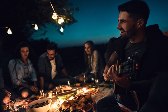 Group of friends camping, enjoy the night with guitar a sing a song