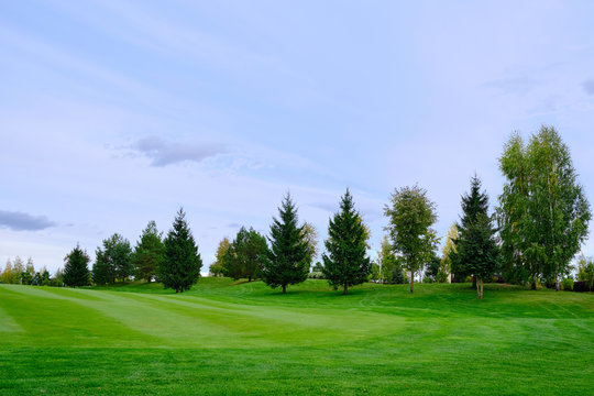 View Of Golf Course With Beautiful Putting Green. Golf Course With A Rich Green Turf Beautiful Scenery.