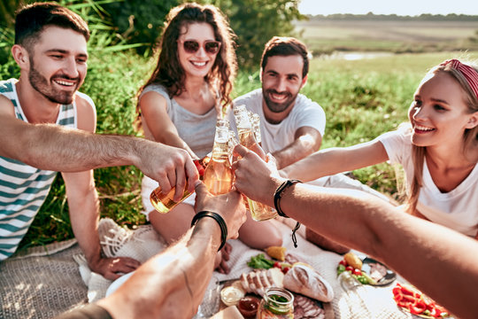 Happy friends cheering with beer bottles at party outdoor