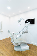 Modern dental practice. Dental chair and other accessories used by dentists in blue, medic light. Medical concept.