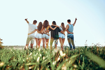 A group of people huddle in a field. - Powered by Adobe