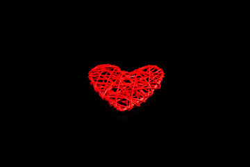 Red heart isolated on a black background.