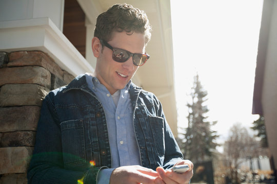attractive man texting on cell phone outside