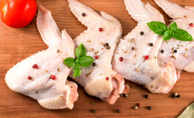 Raw chicken wings. On a wooden background.