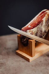 Iberian ham in a wooden ham stand with a knife
