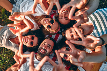 Obraz premium Young cheerful people enjoying on summer meadow