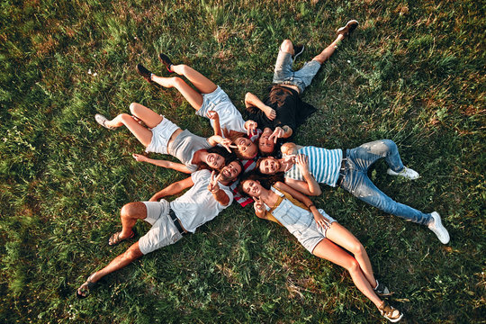 Group of young people having fun in park, lying on the grass