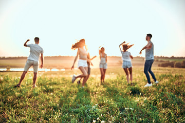 Happiness Friends funny dance on the field under sunset sunlight in summer sunny day.