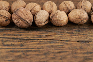 group of walnuts on a wooden board background.