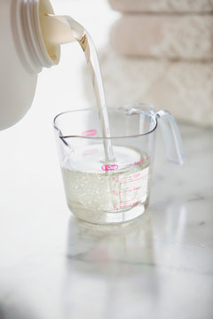 Liquid Detergent Being Poured Into Measuring Cup.