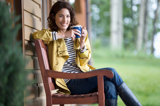 Pretty, Middle-aged Woman Enjoying Coffee Outside Her Cottage