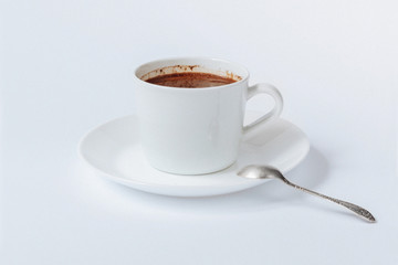 White cup with coffee on tha saucer, and metallic teaspoon isolated on white background