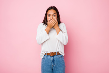 Young mixed race indian woman shocked covering mouth with hands.