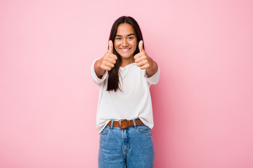 Young mixed race indian woman with thumbs ups, cheers about something, support and respect concept.