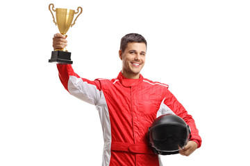Young male car racer standing and holding a helmet and a gold trophy cup - obrazy, fototapety, plakaty
