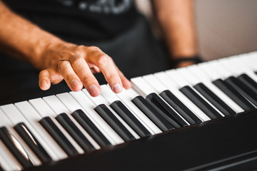 Caucasian man presses piano keys - closeup hand