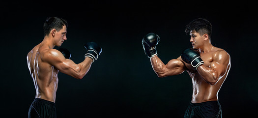 Boxers. Two male fighters in boxing gloves in combat racks on a black background. Fitness concept....
