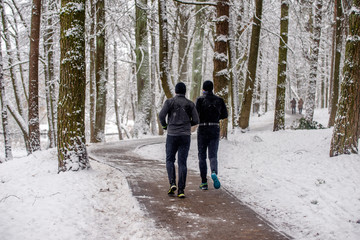 Fototapeta na wymiar Two men go for a run in a winter Park