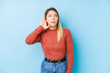 young caucasian woman posing isolated trying to listening a gossip.