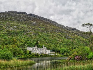 Fototapeta na wymiar Kylemore abbey castle/palace in Ireland, Connemara, County Galway with cloudy and dark weather