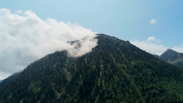 Mysterious Scenic Aerial View of Mountains with Forest and Steam in Clouds. Cinematic Environment Background Footage of Wild Natural Landscape in Alps, Germany. 4K Drone Pull in Zoom Panoramic Shot