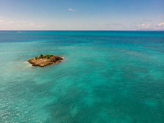 Obraz premium Small island in the middle of the Caribbean sea. Coral reef is around. Amazing Snorkeling destination. 