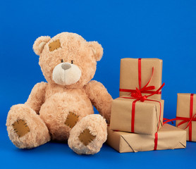big beige teddy bear with patches
