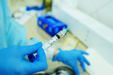 the doctor holds in his hand a syringe with plasma or with a close-up injection for hair regeneration and skin rejuvenation