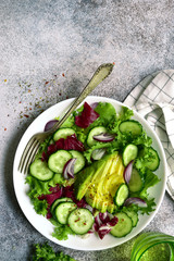 Fresh vegetable salad with avocado and cucumber. Top view with copy space.