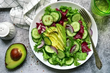 Fotobehang Fresh vegetable salad with avocado and cucumber. Top view with copy space. © lilechka75