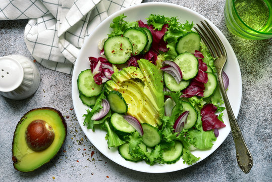 Fresh vegetable salad with avocado and cucumber. Top view with copy space.