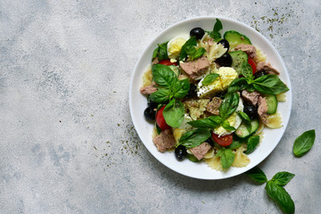 Pasta salad with preserved tuna, vegetables and eggs. Top view with copy space.