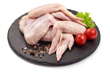 Raw chicken wings on a stone plate, isolated on white background © GSDesign