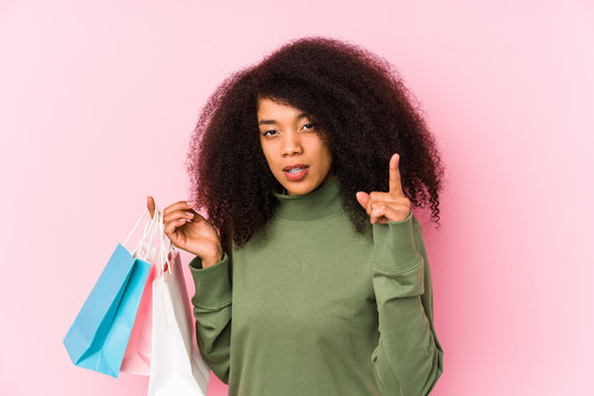 Young afro woman shopping isolated Young afro woman buying isolaYoung afro woman holding a roses isolated having an idea, inspiration concept.< mixto >