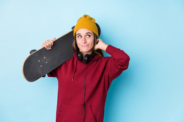 young skater caucasian woman isolated touching back of head, thinking and making a choice.