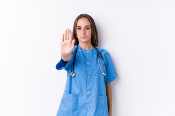 Young nurse woman isolated standing with outstretched hand showing stop sign, preventing you.