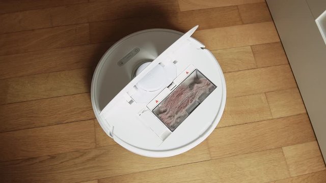 Overhead View Panning Modern Robot Vacuum Parquet Cleaner On Floor With Full Chamber With Dust After Cleaning The House - 4k UHD Footage
