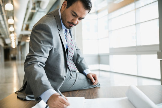 Businessman writing in notebook in office building