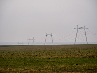 Four electrical pylons supports in a foggy field