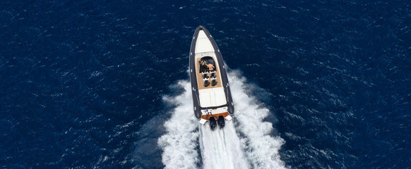 Aerial drone ultra wide top down photo of luxury rib inflatable with wooden deck cruising in deep...