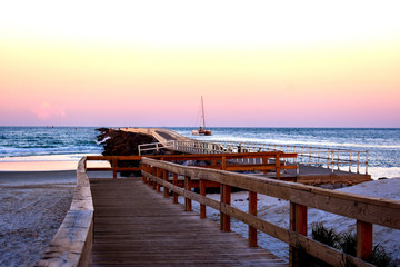 Obraz premium Idyllic Sunset Sailing at the Ponce Inlet Jetty Along the East Coast ofFlorida