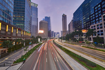 Fototapeta na wymiar Light trails on the busy traffic surrounded by Jakarta business office buildings 