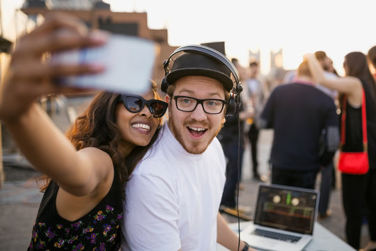 DJ And Woman Taking Selfie At Rooftop Party